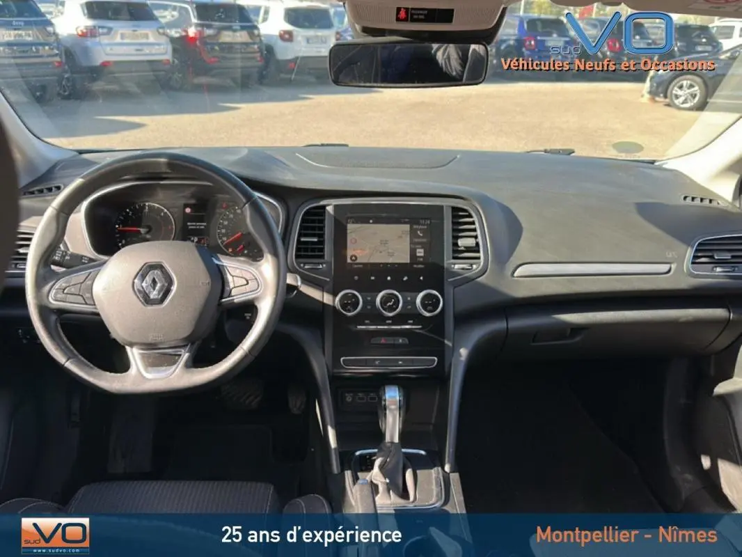 Intérieur de Renault Mégane IV Berline gris clair, vue frontale sur tableau de bord et volant multifonction.