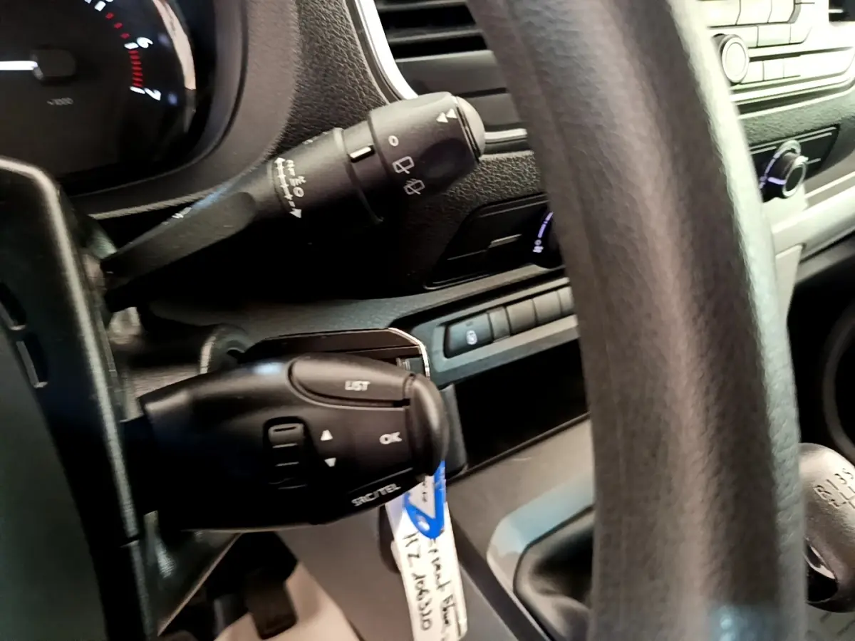 Gros plan sur la colonne de direction et le levier de vitesses manuel d’un Peugeot Traveller blanc de 2018.