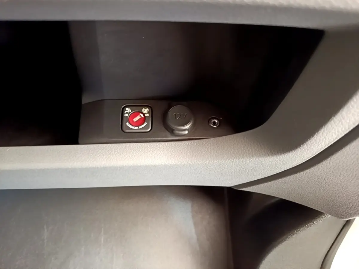 Détail intérieur du Peugeot Traveller 2018 montrant un interrupteur rouge et une prise 12V dans la console centrale.