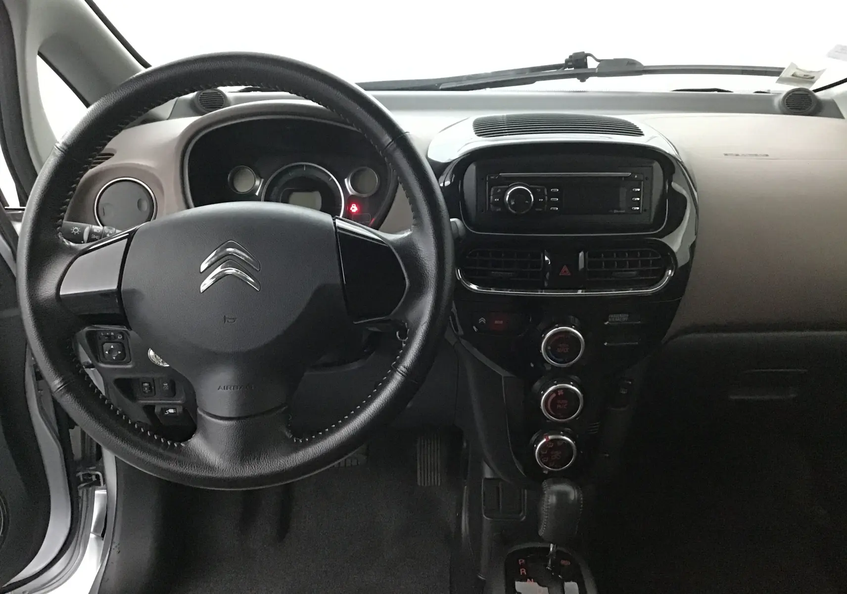 Intérieur de la Citroën C-ZERO gris alu 2018, vue frontale du tableau de bord avec volant et console centrale.