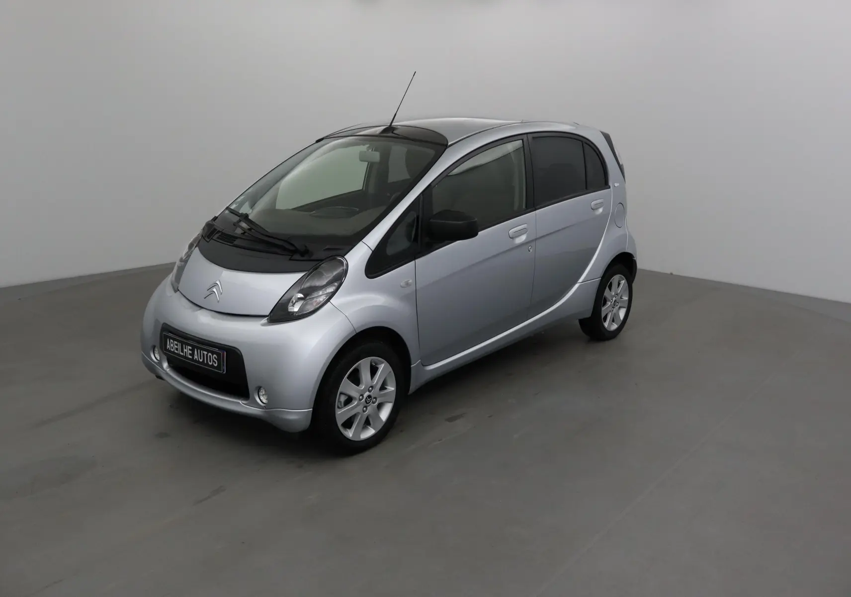Citroën C-ZERO gris alu vue 3/4 avant droit dans un studio, compacte électrique à cinq portes.