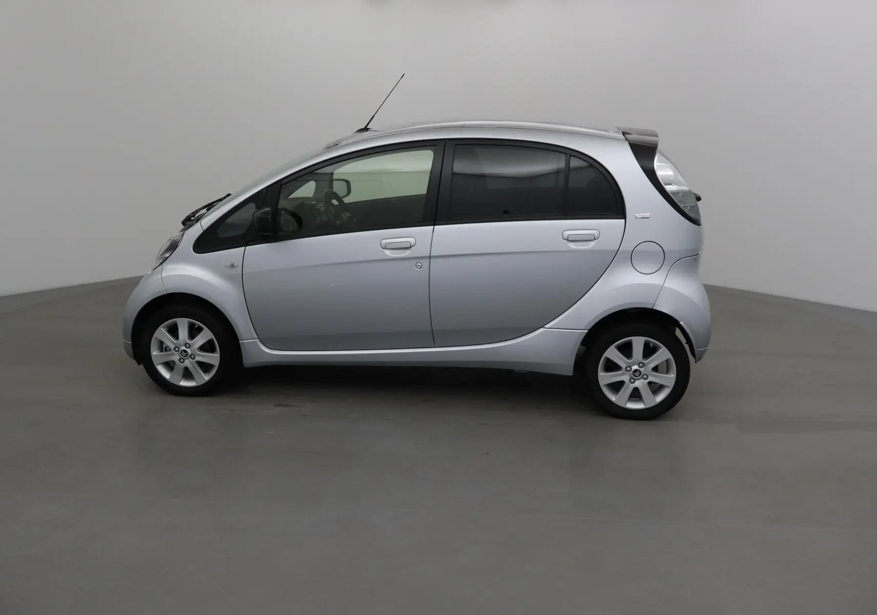 Profil côté gauche d'une Citroën C-ZERO gris alu 2018, compacte et électrique, avec jantes alliage et vitres teintées.