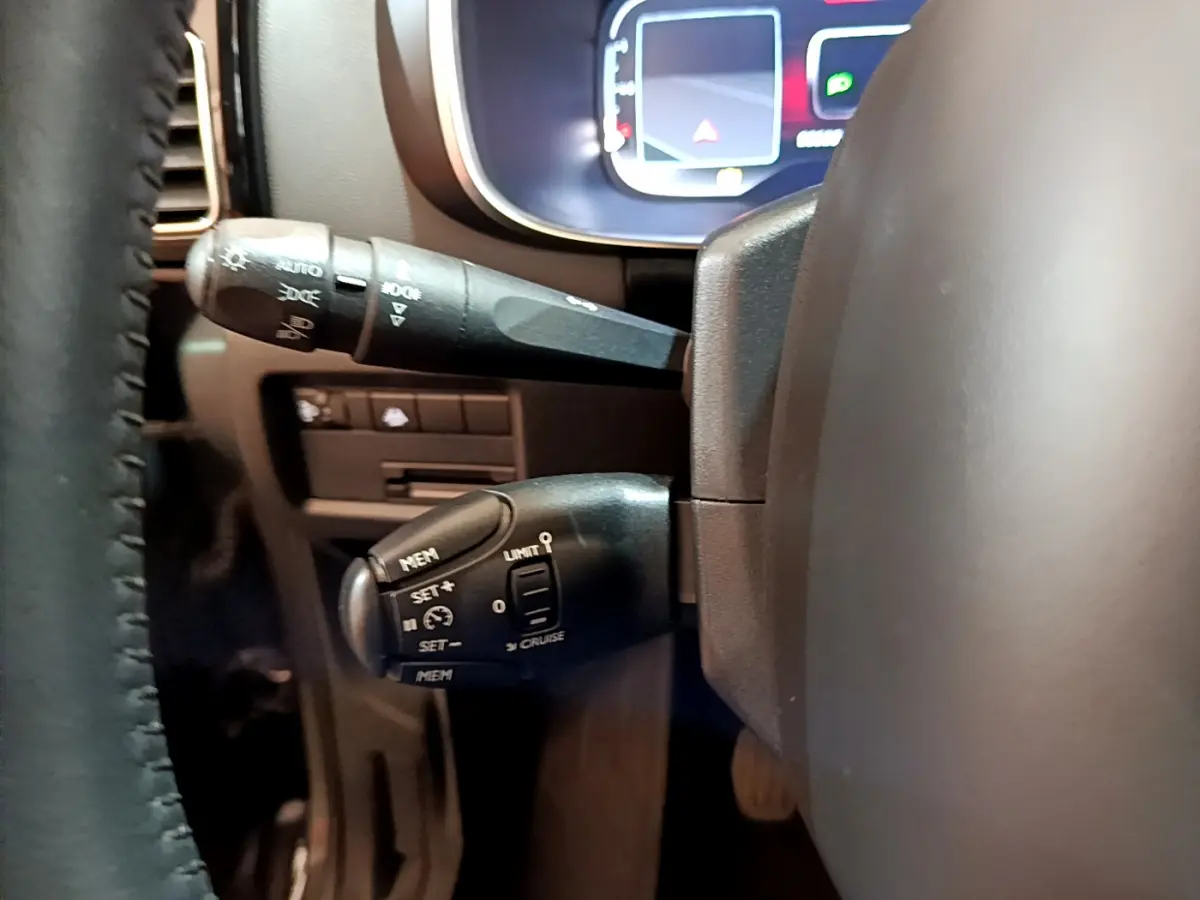 Gros plan sur les commandes au volant noir et le combiné numérique du tableau de bord du Citroën C5 Aircross gris foncé 2020.