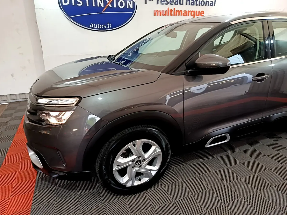 Vue 3/4 avant gauche d'un Citroën C5 Aircross gris foncé avec jantes alliage et inserts Silver Anodisé sur les Airbump.