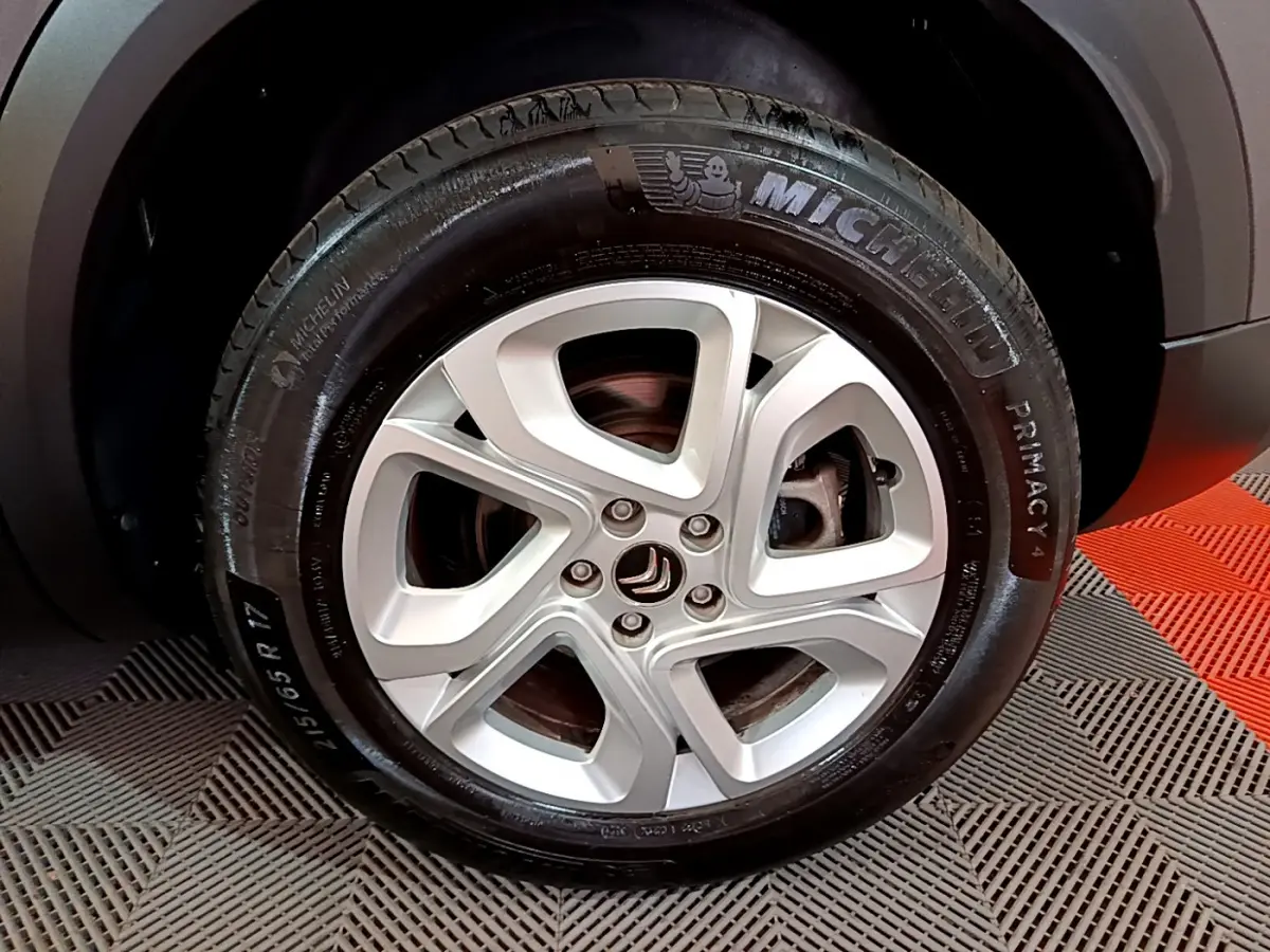 Gros plan sur la jante alliage 17 pouces Ellipse et pneu Michelin d'un Citroën C5 Aircross gris foncé côté droit.