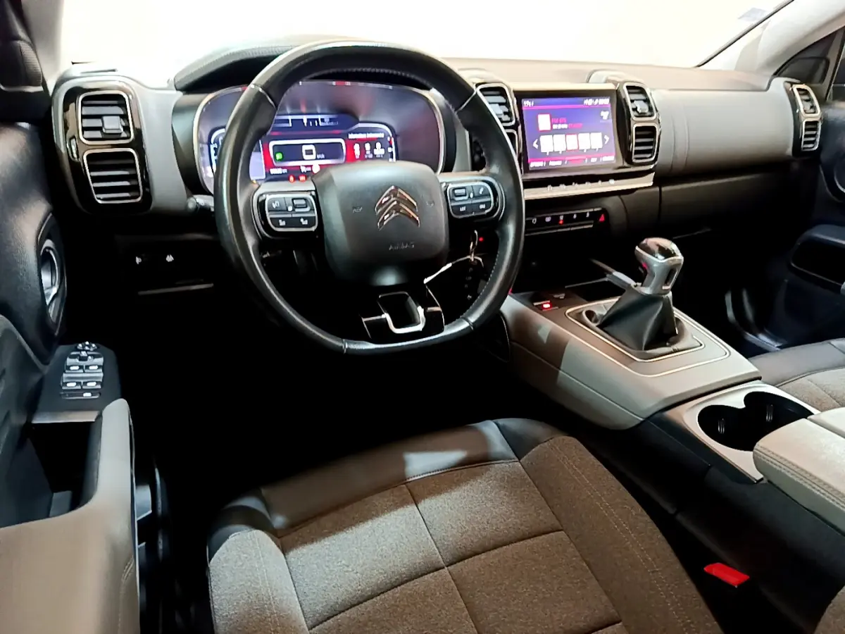 Vue intérieure côté conducteur du Citroën C5 Aircross 2020, volant cuir, combiné numérique et levier de vitesse manuel.