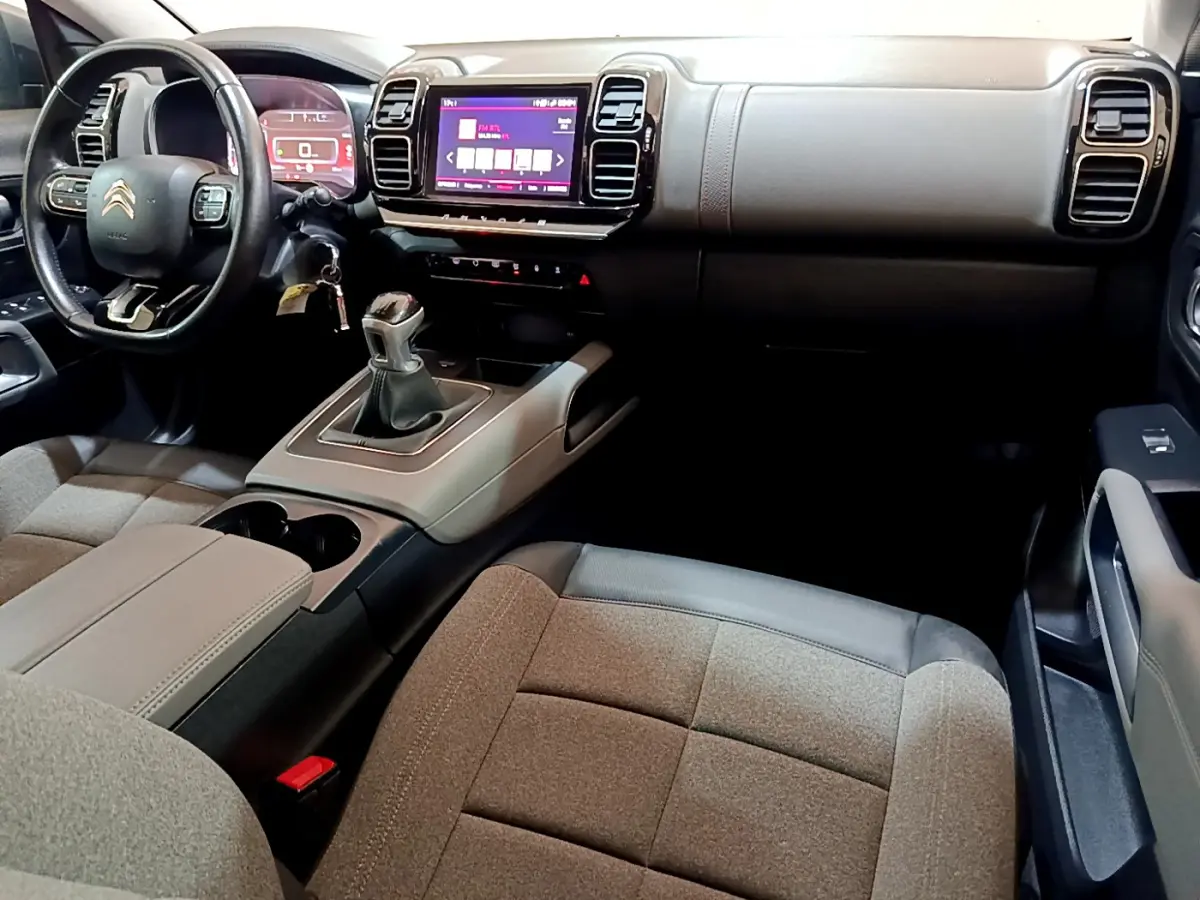 Intérieur du Citroën C5 Aircross 2020, vue du poste de conduite avec volant cuir et console centrale beige et noire.
