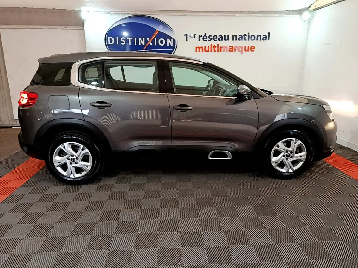 Profil droit d'un Citroën C5 Aircross gris foncé 2020 avec jantes alliage et inserts Silver Anodisé visibles sur le bouclier.