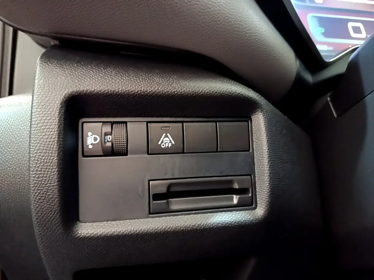 Gros plan sur les commandes de réglage des phares et de l'aide à la conduite dans le tableau de bord noir du Citroën C5 Aircross 2020.