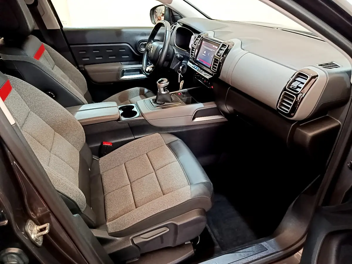 Intérieur avant droit du Citroën C5 Aircross gris foncé 2020, sièges tissu Stone Grey avec cuir noir et console centrale manuelle.