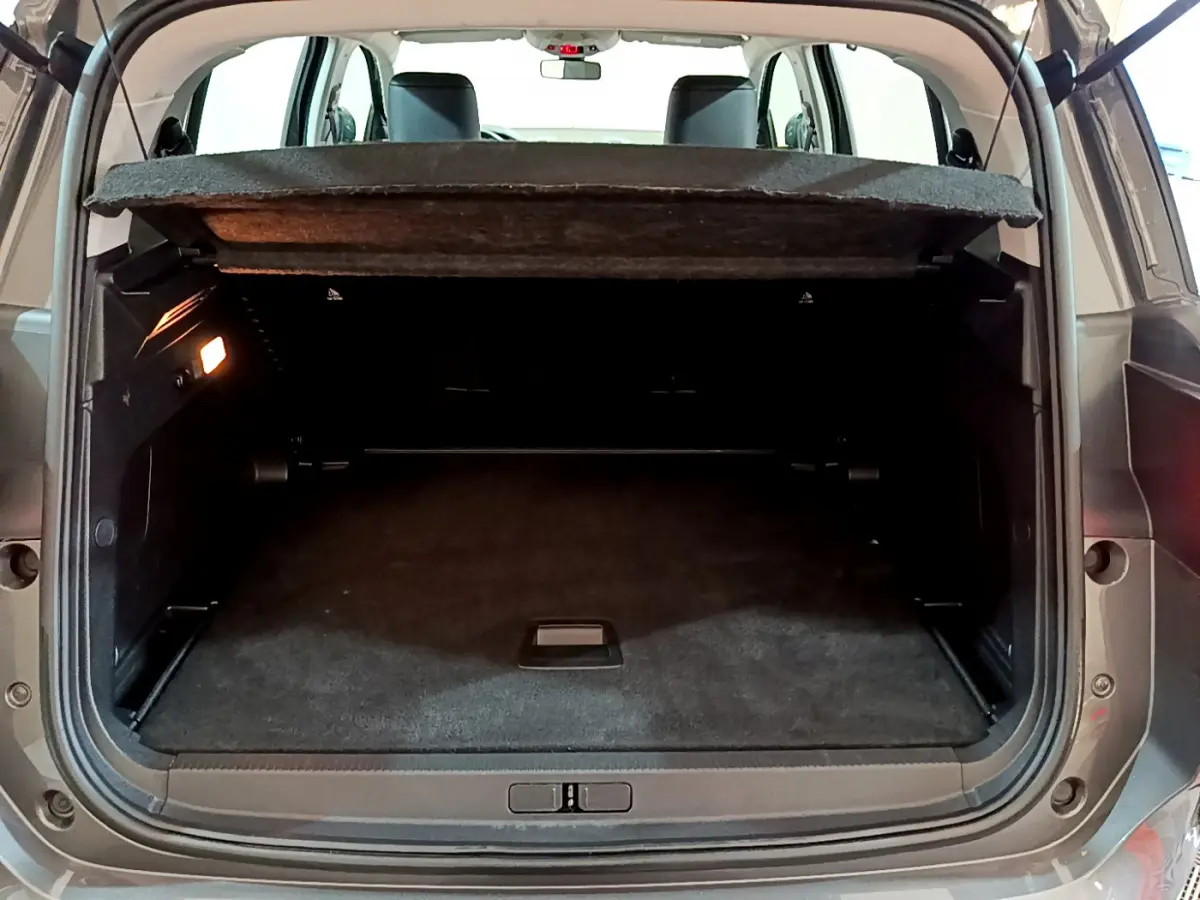 Coffre ouvert vu de l'arrière d'un Citroën C5 Aircross gris foncé, montrant l'espace de chargement et la tablette cache-bagages.