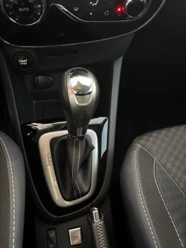 Le levier de vitesse automatique et la console centrale de la Renault Clio IV Estate TCe 120 GT EDC, avec sellerie noire à surpiqûres blanches.