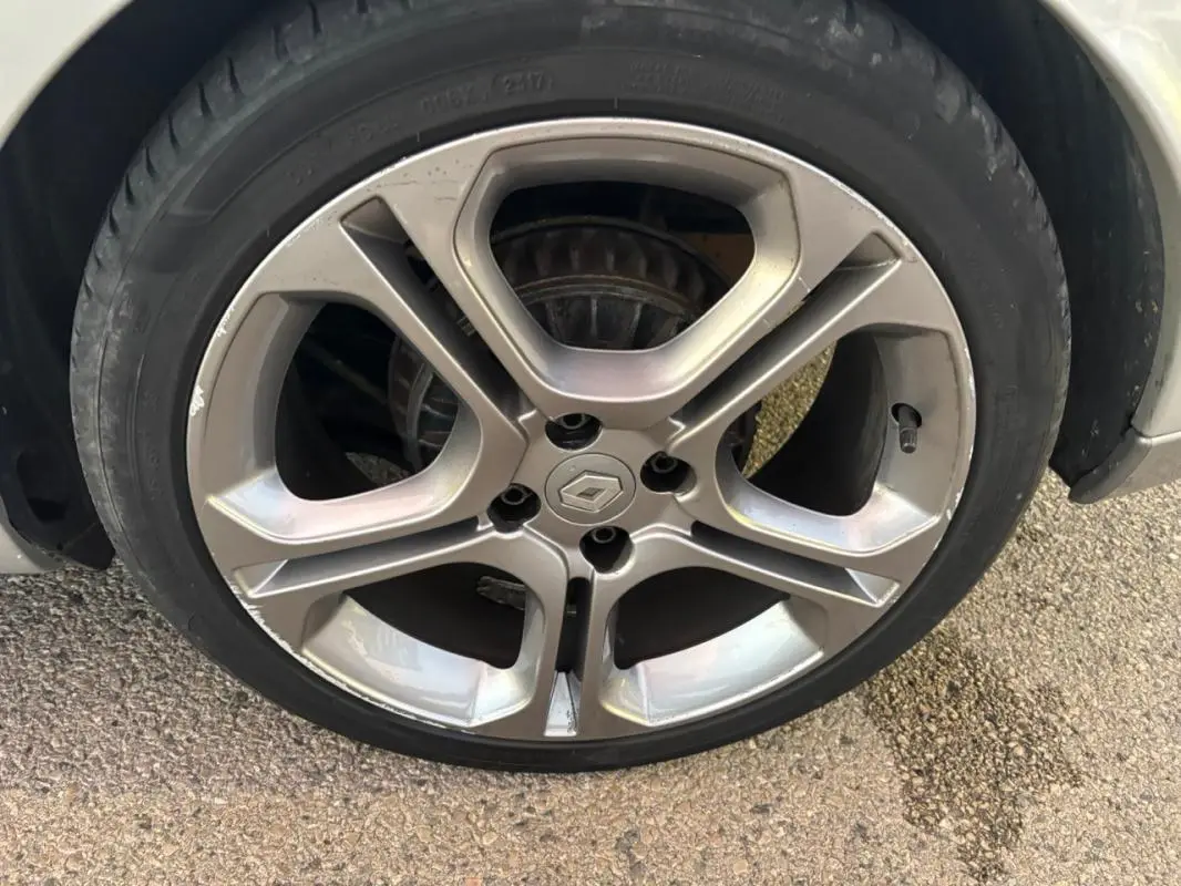 Gros plan sur la jante alliage 17 pouces gris clair d'une Renault Clio IV Estate TCe 120 GT EDC de 2015.