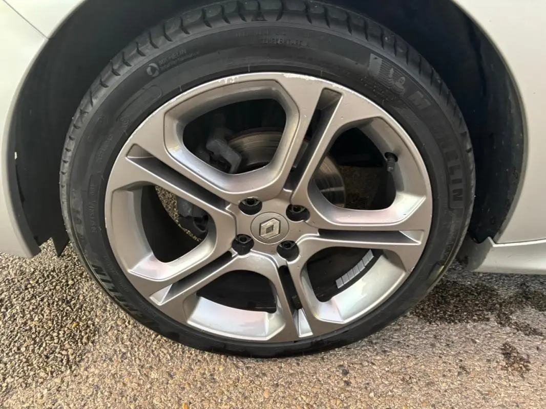 Gros plan sur la jante alliage 17 pouces grise claire d'une Renault Clio IV Estate TCe 120 GT EDC, avec logo Renault central.