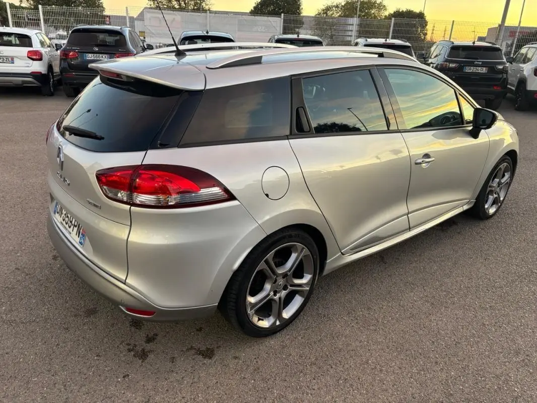 Vue 3/4 arrière droite d'une Renault Clio IV Estate gris clair avec jantes alliage 17 pouces et vitres surteintées.