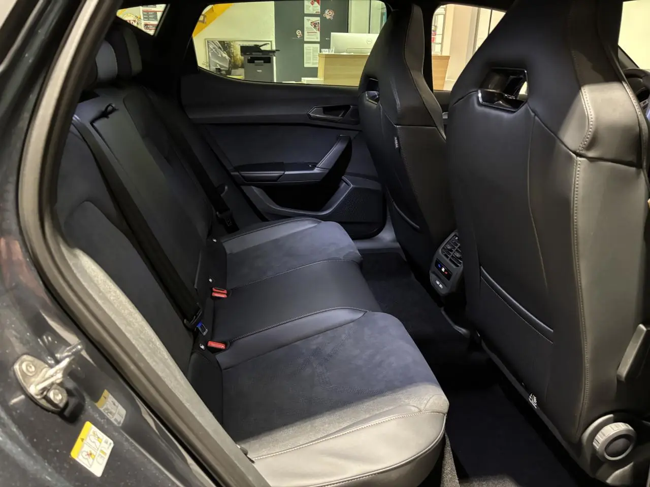 Vue intérieure arrière côté gauche des sièges bimatière noirs et suédine du CUPRA Leon 2.0 TDI gris Graphène 2026.