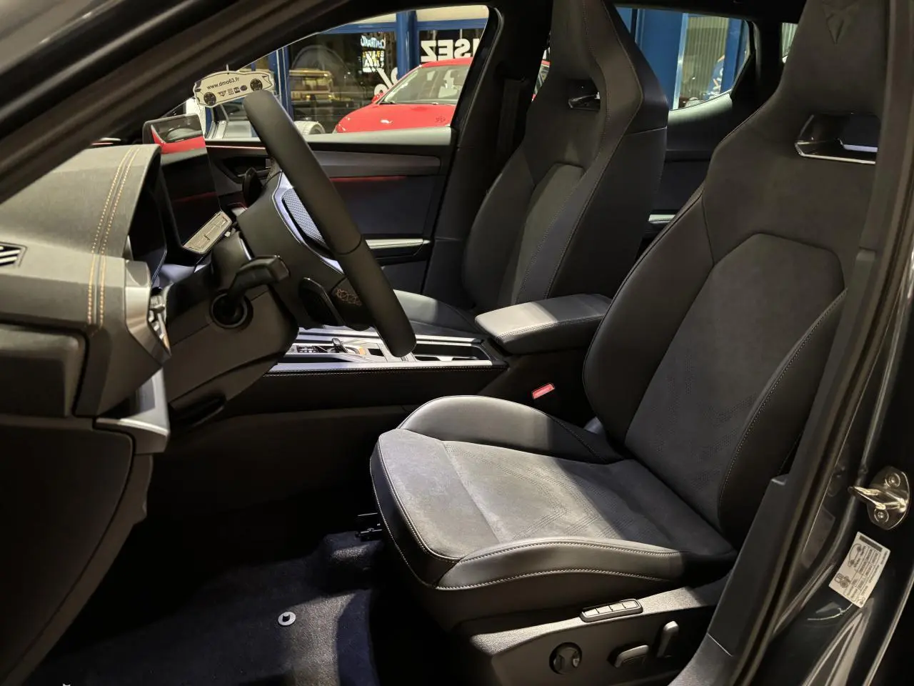 Vue intérieure côté conducteur du CUPRA Leon 2.0 TDI 2026 avec sièges baquets suédine noir et surpiqûres cuivrées.