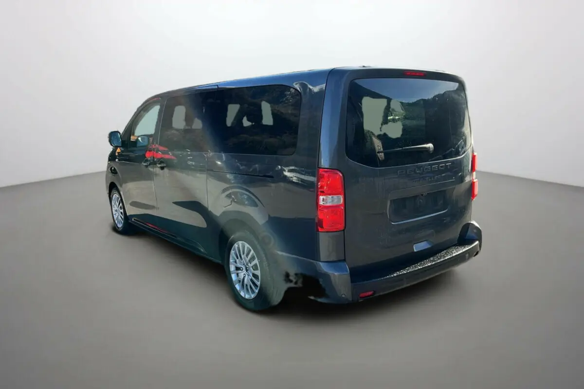 Vue 3/4 arrière droite d’un Peugeot Traveller gris titane avec vitres surteintées et portes latérales coulissantes.