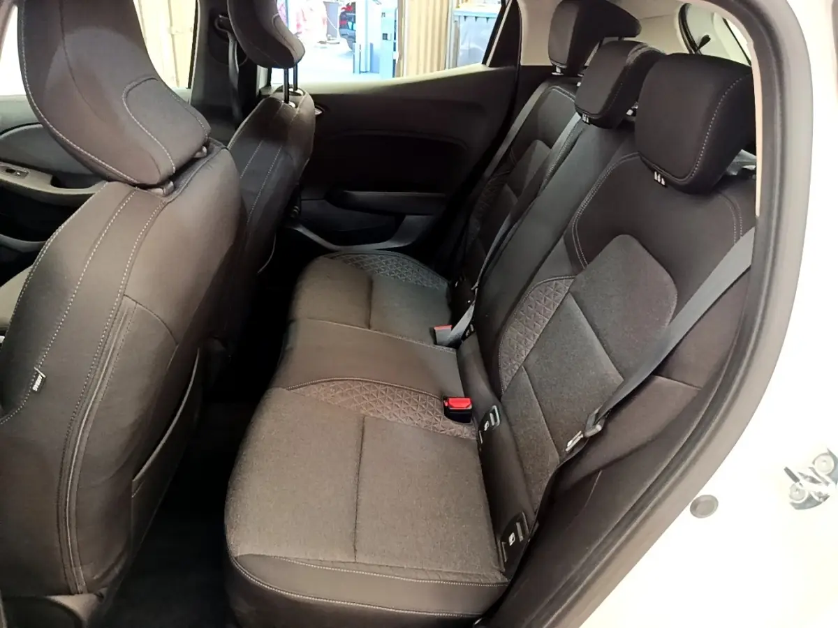 Vue intérieure côté droit montrant la banquette arrière noire avec détails en tissu sur une Renault Clio blanche 2020.