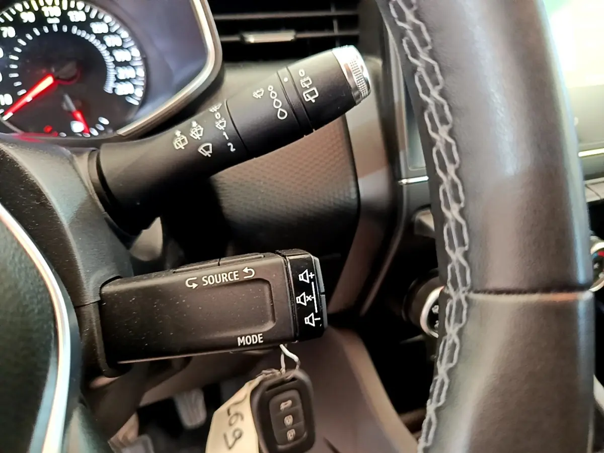 Gros plan sur la commande multimédia au volant d’une Renault Clio Business Blue dCi 85, intérieur noir.