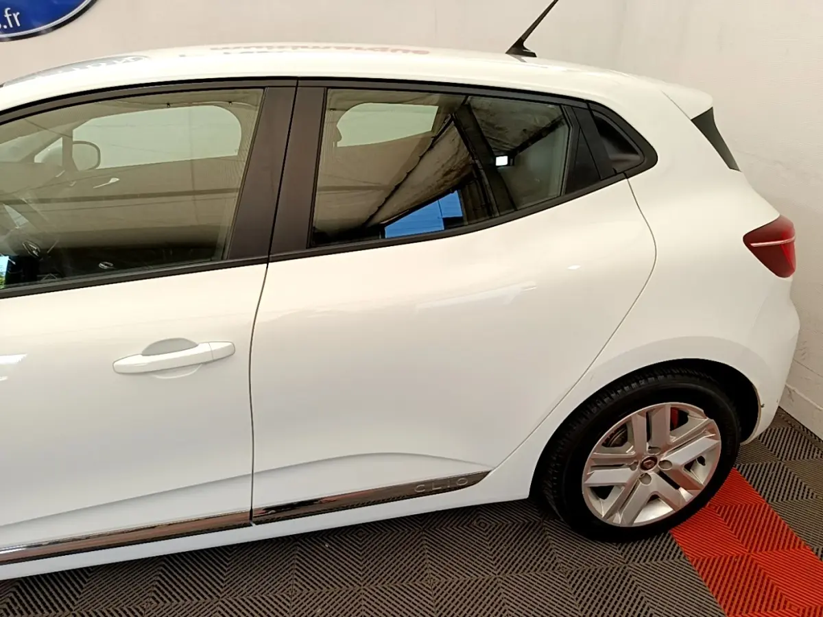 Profil droit de la Renault Clio Business Blue dCi 85 blanche, avec jantes alliage et bandeau chromé bas de porte.