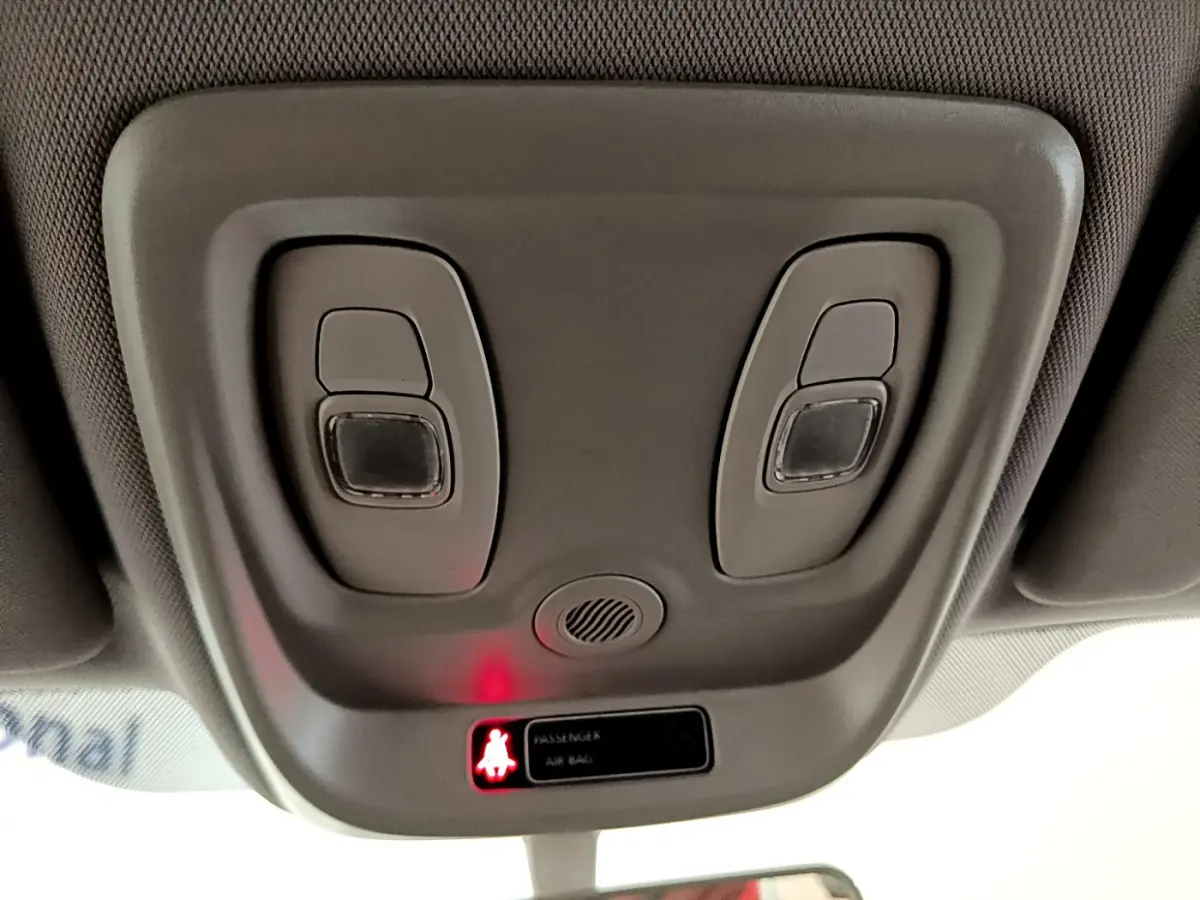 Vue rapprochée du plafonnier gris clair du Renault Captur Business avec éclairage et témoin airbag passager allumé.