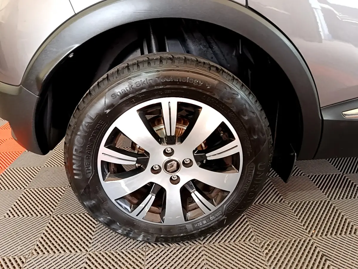 Gros plan sur la roue avant gauche du Renault Captur gris foncé, avec jante alliage et logo Renault central.