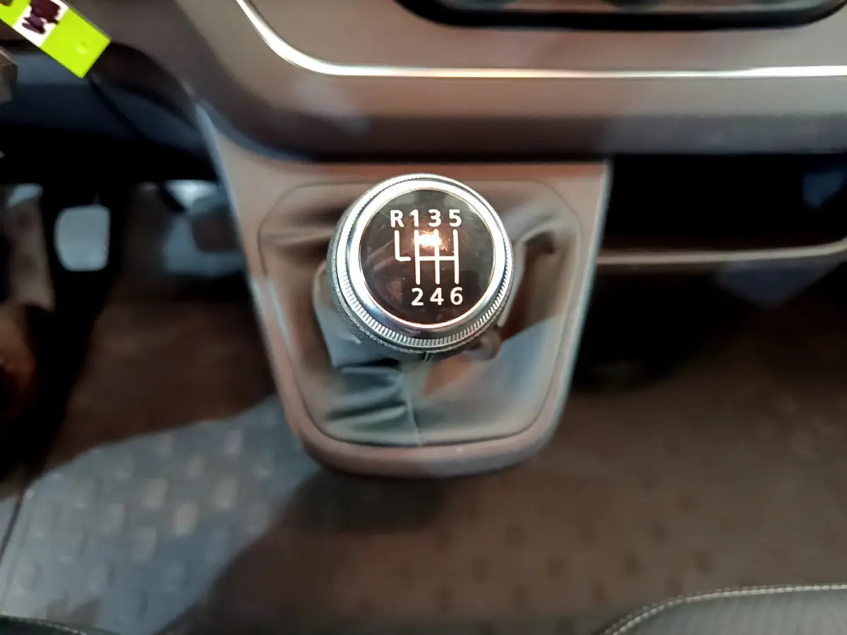Le levier de vitesses manuel du Renault Trafic Fourgon 2022, vue rapprochée sur la console centrale noire.