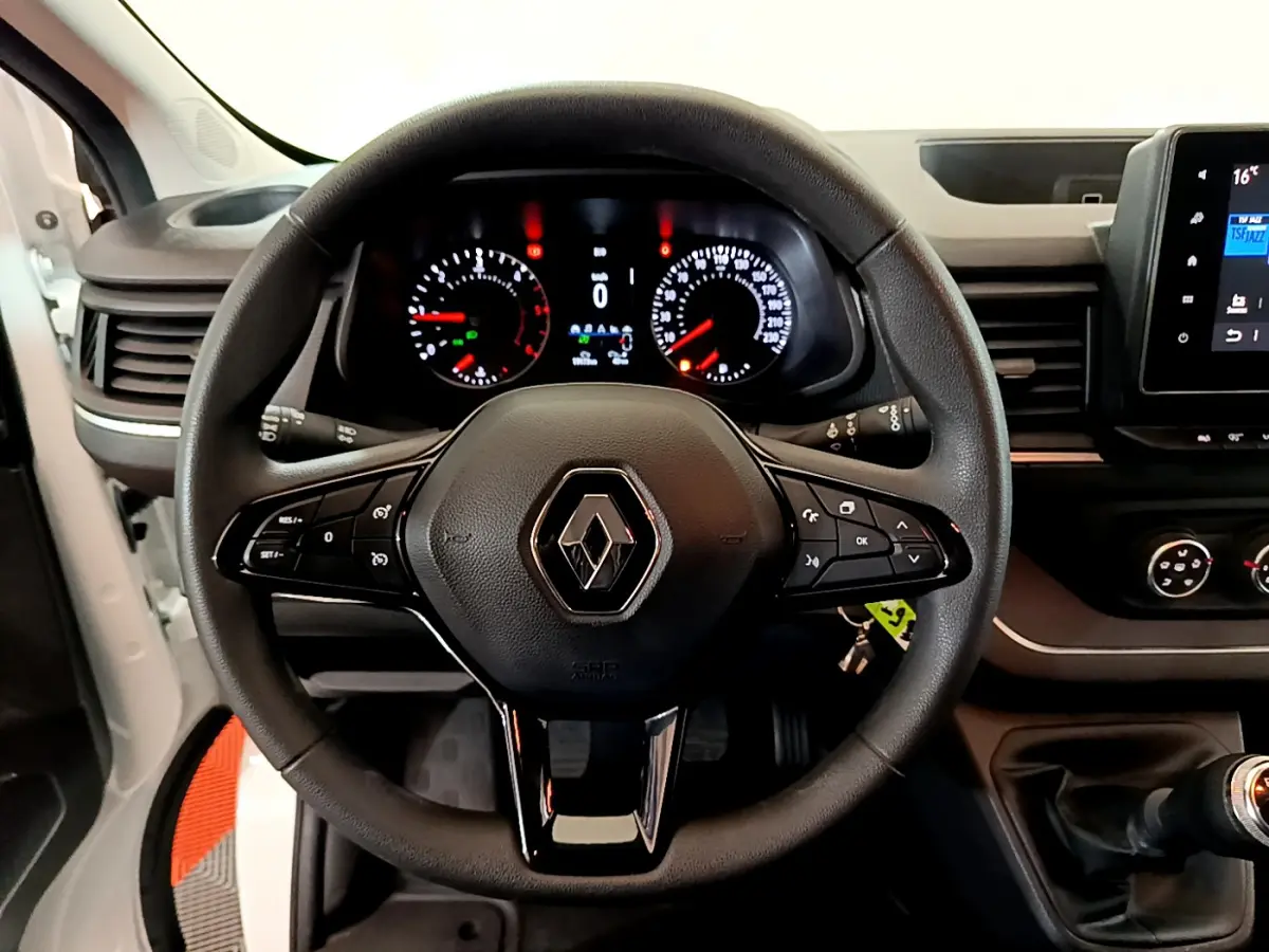 Vue intérieure centrée sur le volant multifonction noir du Renault Trafic Fourgon 2022 avec tableau de bord et levier de vitesse visibles.