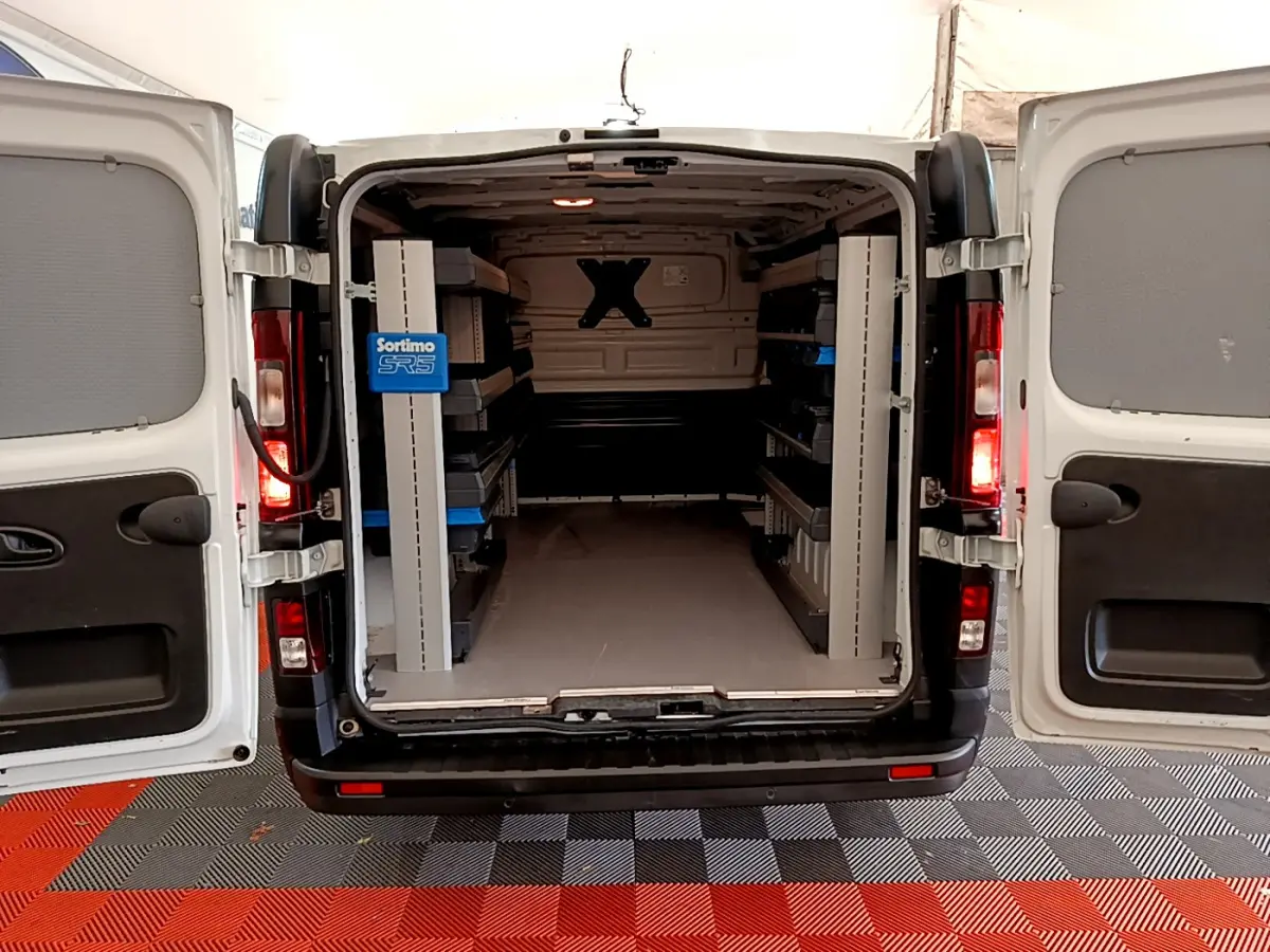 Vue arrière ouverte du Renault Trafic Fourgon blanc 2022 montrant l'intérieur aménagé avec étagères Sortimo SR5.