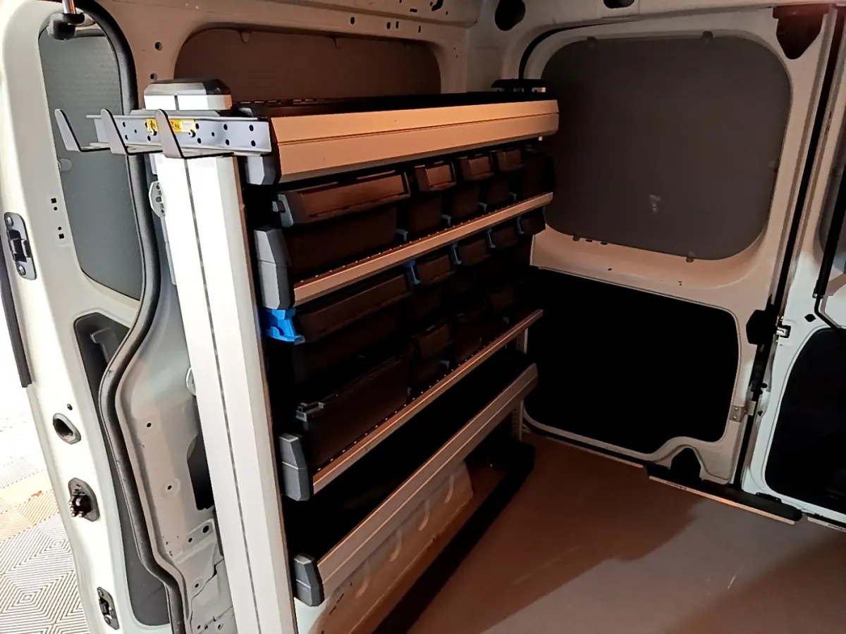 Vue intérieure arrière du fourgon blanc Renault Trafic FG CF L1H1 avec étagères de rangement modulables.
