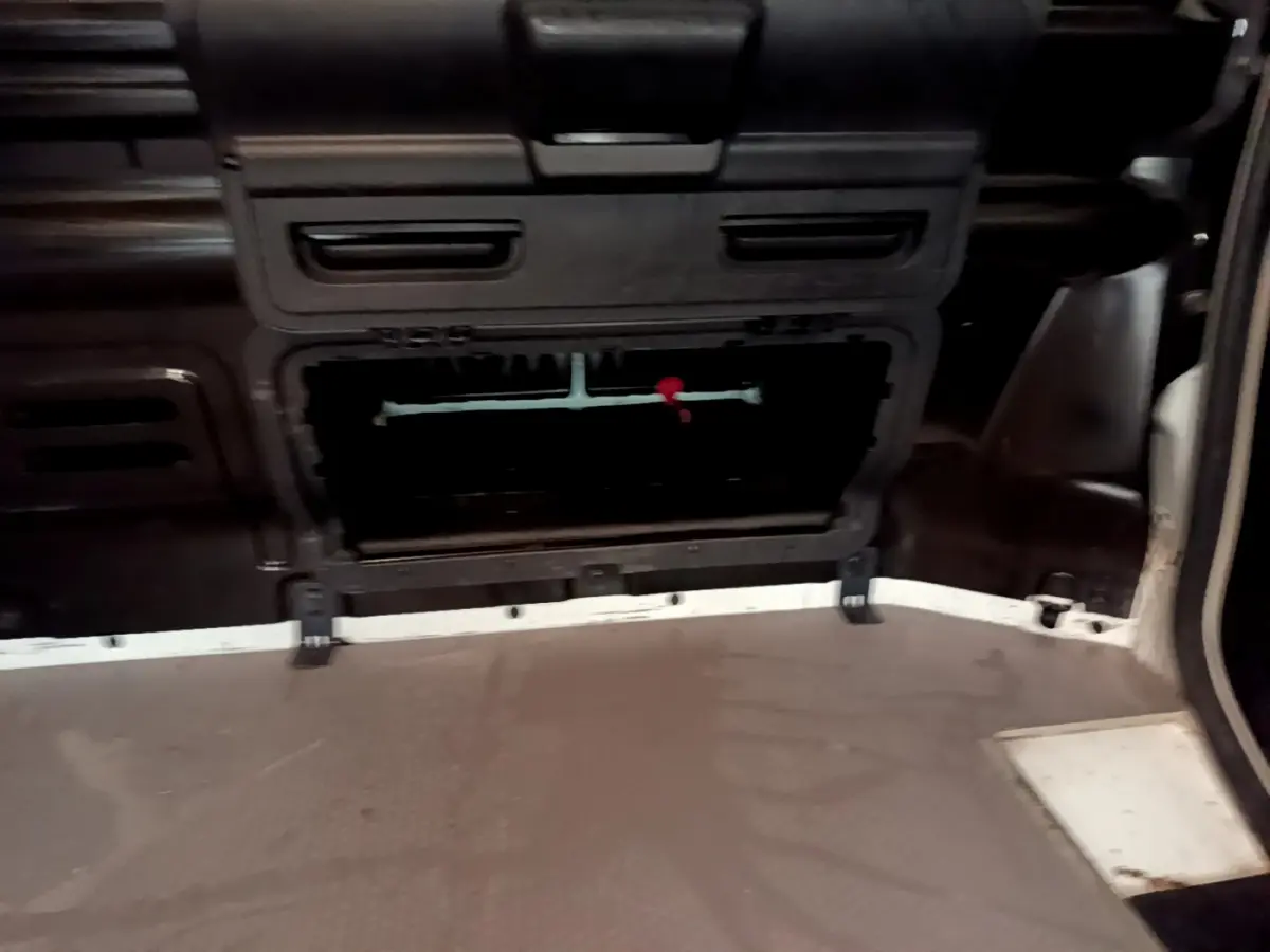 Vue intérieure du compartiment de chargement du Renault Trafic Fourgon blanc, avec cloison pleine et plancher en caoutchouc.