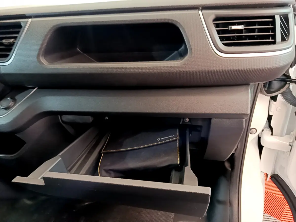 Intérieur du Renault Trafic Fourgon blanc 2022, vue sur la boîte à gants ouverte côté passager avec pochette Renault visible.