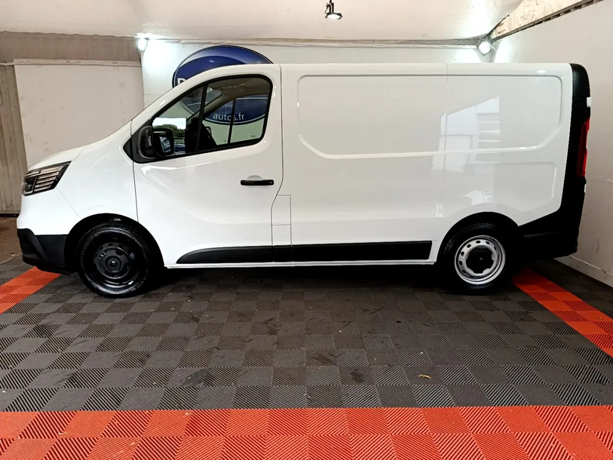 Profil côté gauche d'un fourgon blanc Renault Trafic FG CF L1H1 2T8 Blue dCi 130 de 2022 avec jantes acier noires.