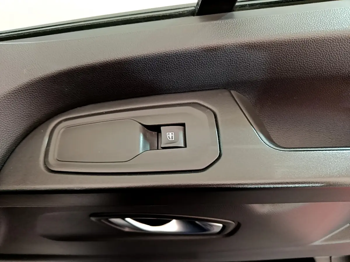 Gros plan sur la commande de lève-vitre côté conducteur du Renault Trafic Fourgon blanc 2022.
