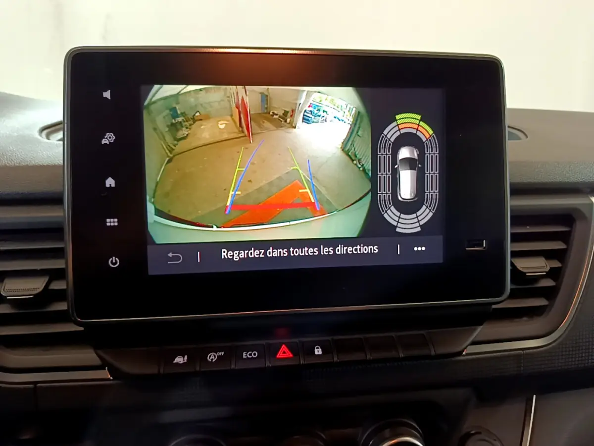 Écran tactile du tableau de bord du Renault Trafic Fourgon blanc 2022 affichant la caméra de recul et les capteurs de stationnement.