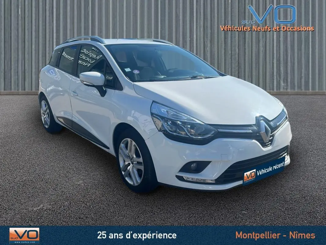 Renault Clio IV Estate Business blanche vue 3/4 avant droit, avec vitres surteintées et feux diurnes LED visibles.