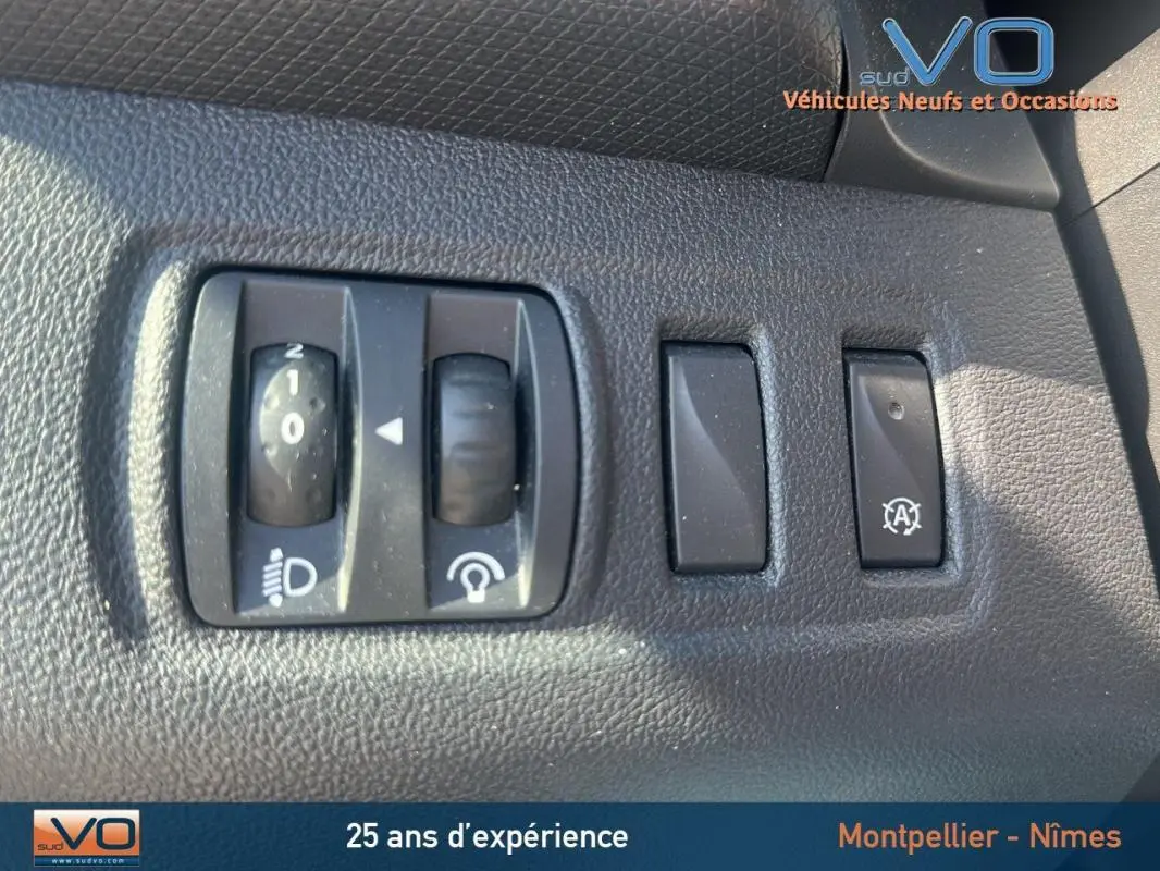 Gros plan sur les commandes d'éclairage et d'assistance au démarrage de la Renault Clio IV Estate Business blanche.