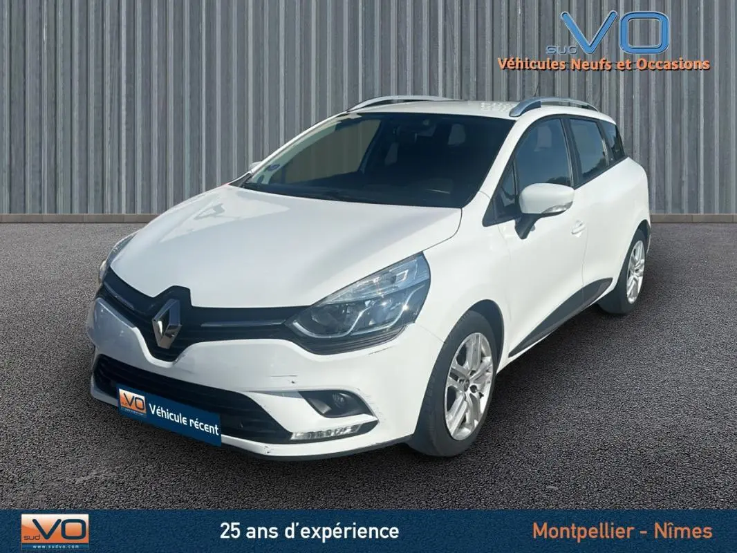 Renault Clio IV Estate Business blanc vue 3/4 avant droit, avec vitres surteintées et jantes alliage visibles.