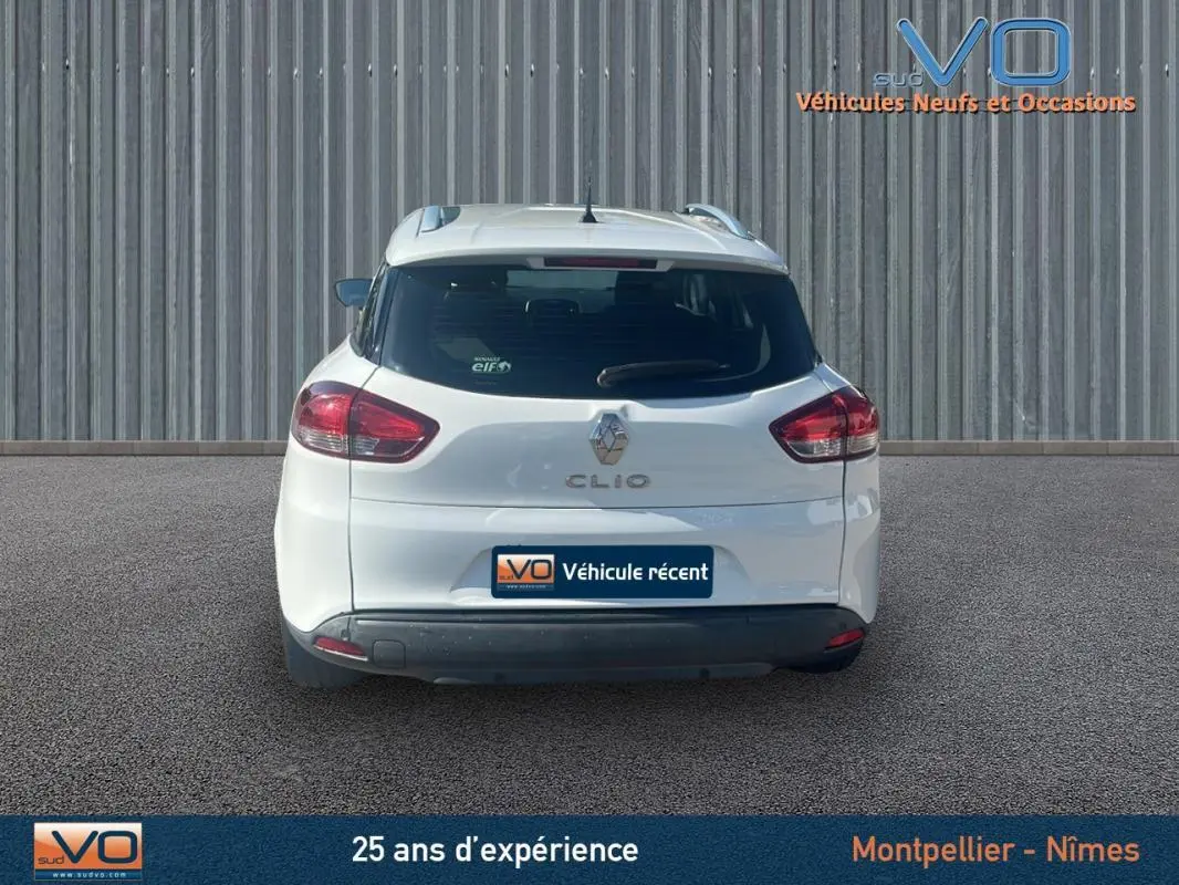 Vue arrière d'une Renault Clio IV Estate Business blanche de 2019 avec vitres surteintées et feux arrière visibles.