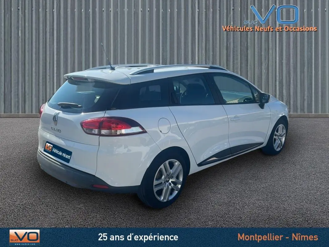 Vue 3/4 arrière droite d'une Renault Clio IV Estate Business blanche avec vitres surteintées et jantes alliage.
