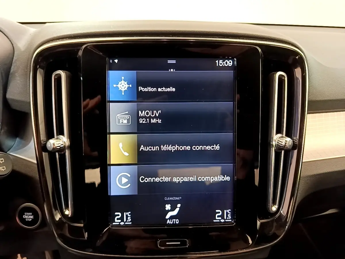 Écran tactile central 9 pouces du tableau de bord noir du Volvo XC40 T2 Momentum, avec commandes climatisation visibles.