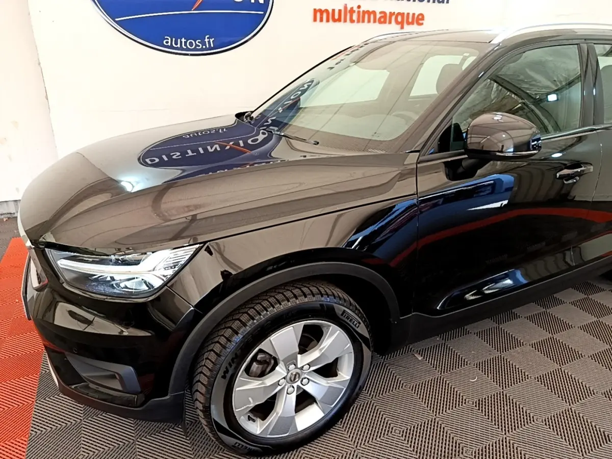 Vue 3/4 avant gauche du Volvo XC40 T2 noir, avec jantes alliage et phares LED distinctifs.