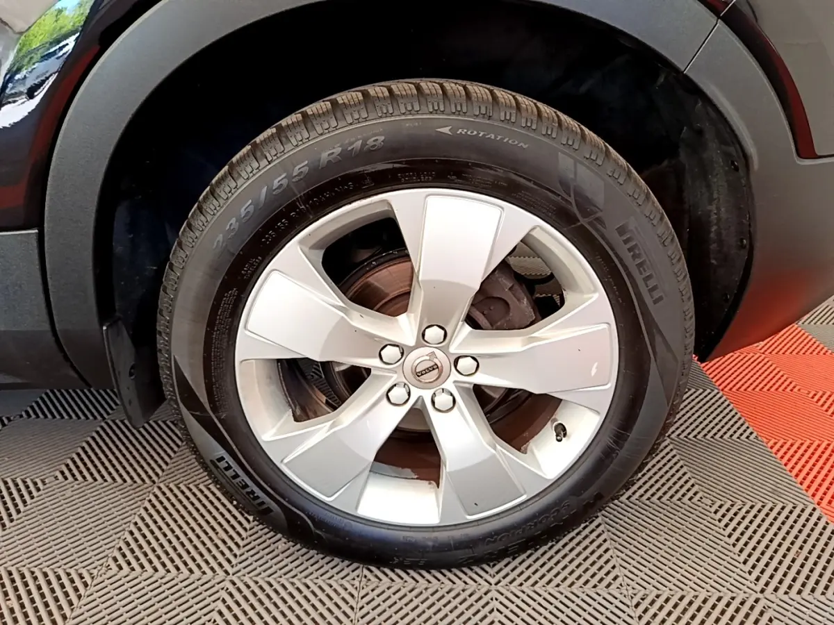 Gros plan sur la roue avant droite d’un Volvo XC40 noir, avec jante alliage argent et pneu Pirelli.