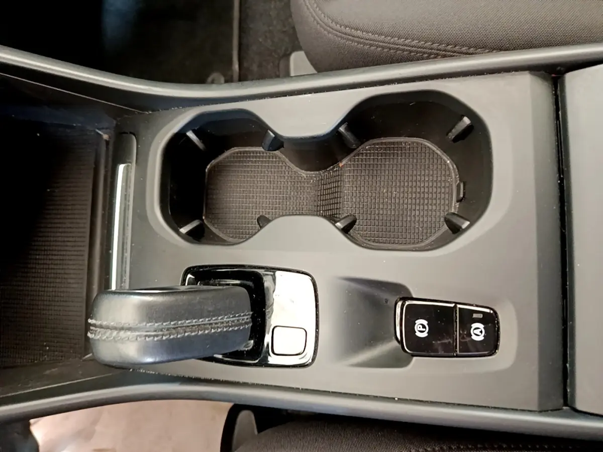 Vue rapprochée de la console centrale noire du Volvo XC40 T2 2020 avec levier de vitesse automatique et boutons de frein à main électrique.