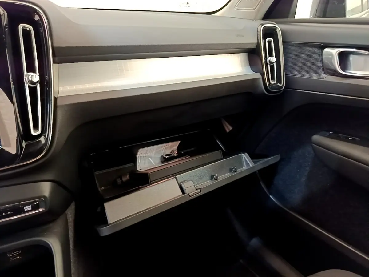 Intérieur de la Volvo XC40 T2 2020, vue côté passager sur la boîte à gants ouverte et tableau de bord clair.