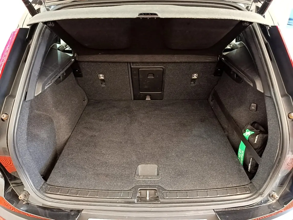 Coffre ouvert vu de l'arrière d'un Volvo XC40 T2 noir, montrant un espace de chargement propre et spacieux.