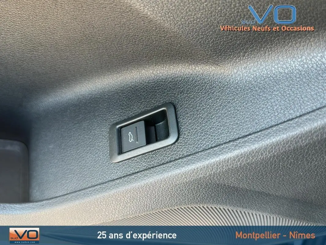 Gros plan sur le bouton d'ouverture du coffre dans l'habitacle d'un Audi Q3 Sportback noir 2020 S line