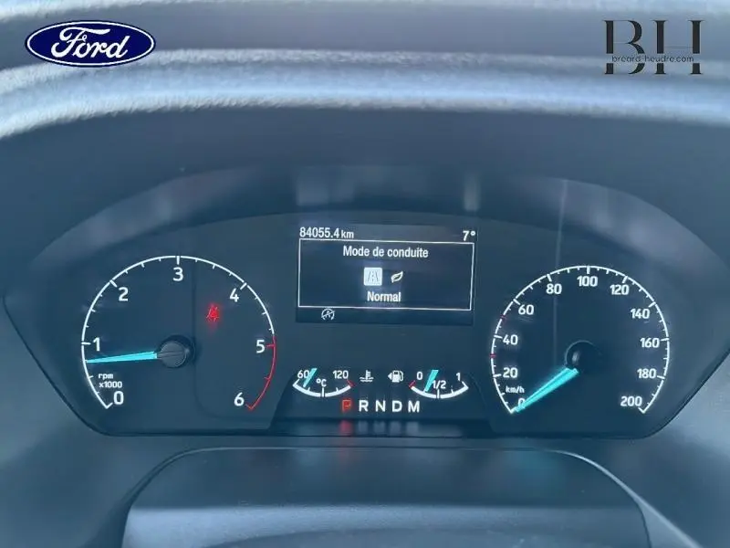 Tableau de bord du Ford Transit Custom noir, affichant mode de conduite normal et compteurs numériques.