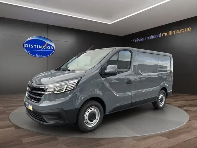 Vue 3/4 avant droit du Renault Trafic Fourgon gris urbain, avec jantes acier et caméra de recul visible sur le hayon arrière.